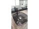 Close up of a modern glass vessel sink, granite counters, and stylish fixtures enhance the bathroom's elegance at 2477 Briar Valley Way, Dacula, GA 30019