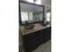 Bathroom vanity with vessel sinks, granite countertop, dark wood cabinets and a large framed mirror at 2477 Briar Valley Way, Dacula, GA 30019