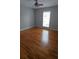 A sunlit bedroom features hardwood flooring, a ceiling fan, and a large window at 2477 Briar Valley Way, Dacula, GA 30019