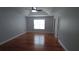 Bright bedroom features hardwood floors, a tray ceiling, and ample natural light from a window at 2477 Briar Valley Way, Dacula, GA 30019