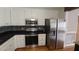 Modern kitchen with stainless steel appliances, white cabinets and a mosaic backsplash at 2477 Briar Valley Way, Dacula, GA 30019