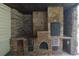 Extravagant outdoor kitchen area with stone walls and wood burning fire brick oven at 2477 Briar Valley Way, Dacula, GA 30019