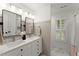 Well-lit bathroom with double vanity, modern fixtures, framed mirrors, and a bright shower area at 4433 Windsor Oaks Cir, Marietta, GA 30066
