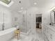 Bright bathroom featuring a freestanding tub, a glass shower, a skylight, and marble floors at 4433 Windsor Oaks Cir, Marietta, GA 30066