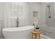 Bathroom featuring a luxurious tub, glass-enclosed shower, and elegant fixtures and a bright window view at 4433 Windsor Oaks Cir, Marietta, GA 30066