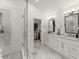 Bathroom featuring dual sinks with white marble countertops, white cabinets, black hardware, a glass shower, and a walk-in closet at 4433 Windsor Oaks Cir, Marietta, GA 30066