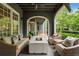 Relaxing back porch with comfortable seating, a modern fire pit, and a view of the landscaped backyard at 6805 Bucks Rd, Cumming, GA 30040