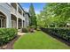 Manicured backyard with lush lawn, mature trees, and a wrought iron fence offers a private and serene outdoor space at 6805 Bucks Rd, Cumming, GA 30040