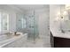 Elegant bathroom featuring marble finishes, a soaking tub, a glass-enclosed shower, and modern fixtures at 6805 Bucks Rd, Cumming, GA 30040