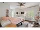 Bright bedroom features a ceiling fan, hardwood floors, and a large window with white shutters, offering a comfortable and inviting space at 6805 Bucks Rd, Cumming, GA 30040