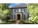 Charming two-story home featuring gray siding, black shutters, and a stone archway at the entrance at 6805 Bucks Rd, Cumming, GA 30040