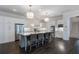 Bright, modern kitchen features a center island with seating and ample white cabinetry with stainless steel appliances at 6805 Bucks Rd, Cumming, GA 30040