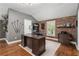 Home office boasts a modern desk, exposed brick accent wall, and natural light, providing a productive workspace at 6805 Bucks Rd, Cumming, GA 30040