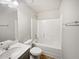 Bright bathroom with white tile tub, single sink vanity, and wood look flooring at 7119 Gladstone Cir, Lithonia, GA 30038