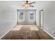 A sunlit bedroom featuring neutral walls, carpet, two windows, and a spacious closet at 7119 Gladstone Cir, Lithonia, GA 30038