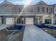 Modern townhome featuring a gray exterior with a private garage and manicured landscaping at 7119 Gladstone Cir, Lithonia, GA 30038