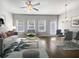 A bright living room with a ceiling fan, hardwood floors, and natural light from the windows at 7119 Gladstone Cir, Lithonia, GA 30038