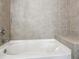 Close up of a neutral bathtub and tiled wall with a built-in seat at 950 W Peachtree Nw St # 1214, Atlanta, GA 30309