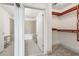 Walk-in closet with custom shelving leading into a tiled bathroom with a shower and tub at 950 W Peachtree Nw St # 1214, Atlanta, GA 30309