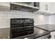 Modern kitchen with stainless steel microwave and oven, white subway tile backsplash, and gray countertops at 950 W Peachtree Nw St # 1214, Atlanta, GA 30309