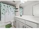 Bathroom featuring a shower-tub combo with a stylish green leaf shower curtain and gray cabinets at 100 Grove View Rd, Woodstock, GA 30189