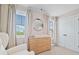 Bedroom features two windows, a changing table, and soft, neutral tones to create a calming atmosphere at 100 Grove View Rd, Woodstock, GA 30189