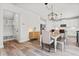 Open-concept dining area with modern lighting, wooden table, and adjacent kitchen at 100 Grove View Rd, Woodstock, GA 30189