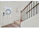 Bright entryway featuring a classic staircase with wood railing and trim at 100 Grove View Rd, Woodstock, GA 30189