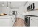 Bright kitchen featuring white cabinets, stainless steel appliances, and quartz countertops at 100 Grove View Rd, Woodstock, GA 30189