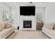 Bright living room features a cozy fireplace, mounted television, and neutral decor at 100 Grove View Rd, Woodstock, GA 30189