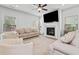 Open concept living room with a fireplace, ceiling fan and comfortable neutral furniture at 100 Grove View Rd, Woodstock, GA 30189