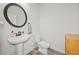 Compact powder room featuring a pedestal sink, toilet, and decorative mirror at 100 Grove View Rd, Woodstock, GA 30189