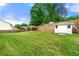 Exterior shot of a large green lawn, storage shed and a covered patio at 3700 Long Lake Dr, Douglasville, GA 30135