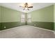 This bedroom features green-painted walls, neutral carpet, a ceiling fan and two windows at 3700 Long Lake Dr, Douglasville, GA 30135