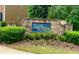 Stone community entrance sign with colorful flowers and lush greenery offers an inviting welcome to residents and visitors at 3700 Long Lake Dr, Douglasville, GA 30135