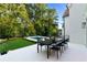 Backyard patio area featuring an outdoor dining set, green grass, and a view of the swimming pool and lush trees at 490 Mount Paran Rd, Atlanta, GA 30327