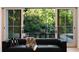 Modern living room with large sliding glass doors leading to a patio and backyard surrounded by green trees at 490 Mount Paran Rd, Atlanta, GA 30327