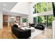 Open floor plan of a living room with floor-to-ceiling windows overlooking the backyard. Access to kitchen at 490 Mount Paran Rd, Atlanta, GA 30327
