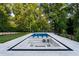 A large in-ground swimming pool with a built-in lounge area with a fire pit and views of the backyard at 490 Mount Paran Rd, Atlanta, GA 30327