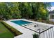An in-ground swimming pool with a built-in lounge area featuring cushioned seating and a charming fire pit at 490 Mount Paran Rd, Atlanta, GA 30327