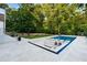 An in-ground swimming pool with a built-in lounge area featuring cushioned seating and a charming fire pit at 490 Mount Paran Rd, Atlanta, GA 30327