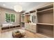 Spacious walk-in closet with custom shelving, storage drawers, a bench seat and a window letting in lots of light at 490 Mount Paran Rd, Atlanta, GA 30327