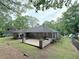 Aerial view of home's backyard featuring a concrete patio, wood deck, and mature trees at 1341 Beeblossom Trl, Lawrenceville, GA 30044