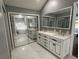 Bright bathroom featuring double vanity, marble floors, mirrored closet doors, and modern lighting at 1341 Beeblossom Trl, Lawrenceville, GA 30044
