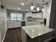 Bright kitchen features white cabinets, modern pendant lighting, stainless steel appliances, and large island at 1341 Beeblossom Trl, Lawrenceville, GA 30044