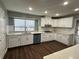 Well-lit kitchen featuring white cabinetry, quartz countertops and stainless steel appliances at 1341 Beeblossom Trl, Lawrenceville, GA 30044