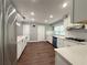Modern kitchen featuring stainless steel appliances, white cabinets, quartz countertops, and hardwood floors at 1341 Beeblossom Trl, Lawrenceville, GA 30044