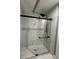 Modern glass shower featuring black hardware, rainfall shower head, and marble wall tiles at 1341 Beeblossom Trl, Lawrenceville, GA 30044