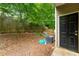 Exterior shot of a wooded backyard with a black back door and side of the home at 4670 Ernest Dr, Forest Park, GA 30297