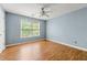 Bright bedroom features a ceiling fan, natural light from the large window, and wood-look laminate flooring at 4670 Ernest Dr, Forest Park, GA 30297